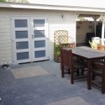 houten tuinhuis met terrasoverkapping in wit geschilderd